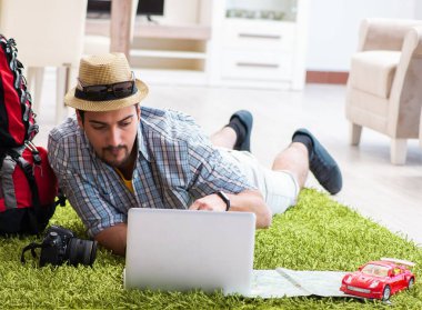 Genç adam internetten seyahat etmeyi planlıyor.