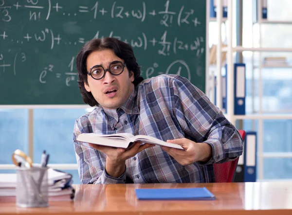 Mladý vtipný učitel matematiky před tabulí — Stock fotografie