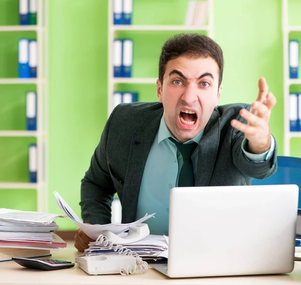 Бізнесмен сердиться на надмірну роботу, сидячи в офісі — стокове фото