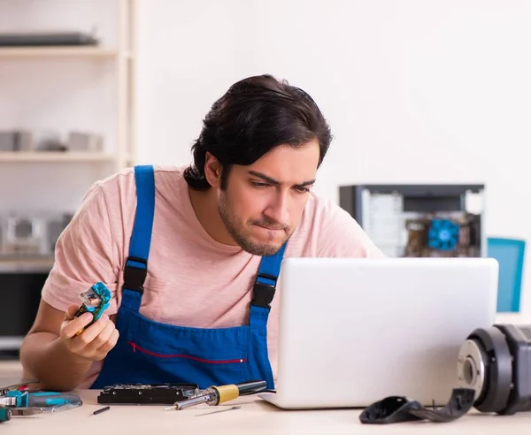 O jovem empreiteiro do sexo masculino reparar computador — Fotografia de Stock