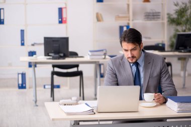 Molada kahve içen genç bir erkek.