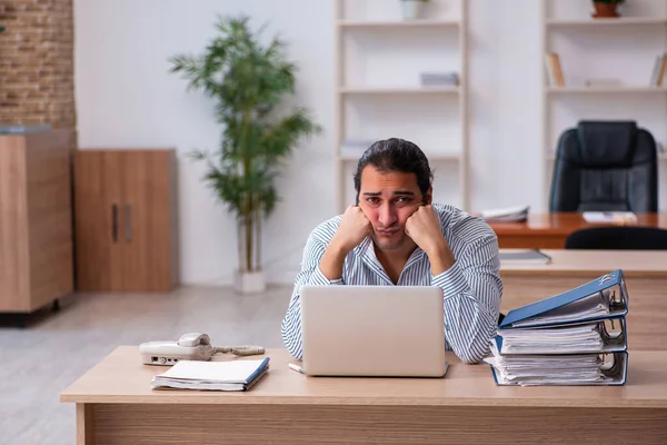 Joven empleado masculino infeliz con el trabajo excesivo —  Fotos de Stock