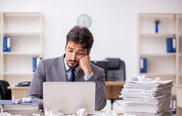 Joven empleado masculino y demasiado trabajo en la oficina — Foto de Stock