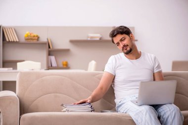 Genç erkek çalışan salgın sırasında evden çalışıyor.