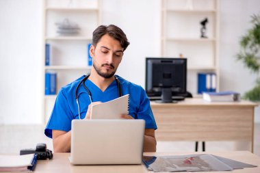 Klinikte çalışan genç erkek doktor.