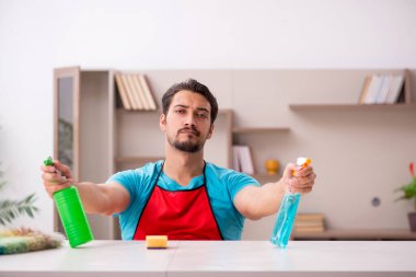 Genç erkek müteahhit evi temizliyor.