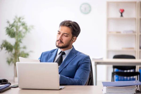 Gehörlose männliche Angestellte mit Hörgerät am Arbeitsplatz — Stockfoto