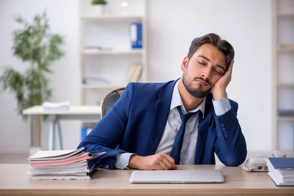 Jovem funcionário masculino extremamente cansado no escritório — Fotografia de Stock