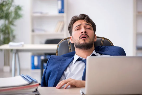 Joven empleado masculino extremadamente cansado en la oficina — Foto de Stock