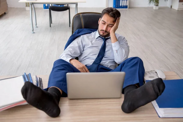 Joven empleado masculino extremadamente cansado en la oficina —  Fotos de Stock