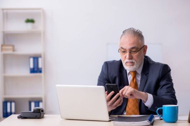 Ofiste çalışan yaşlı bir erkek.