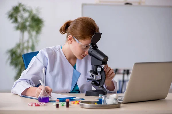 Jeune chimiste féminine dans le concept de synthèse de médicaments — Photo