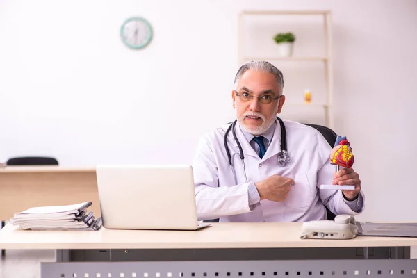 Åldrad manlig läkare kardiolog arbetar på kliniken — Stockfoto