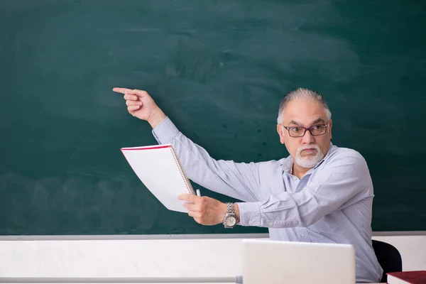 Viejo profesor delante del tablero verde — Foto de Stock