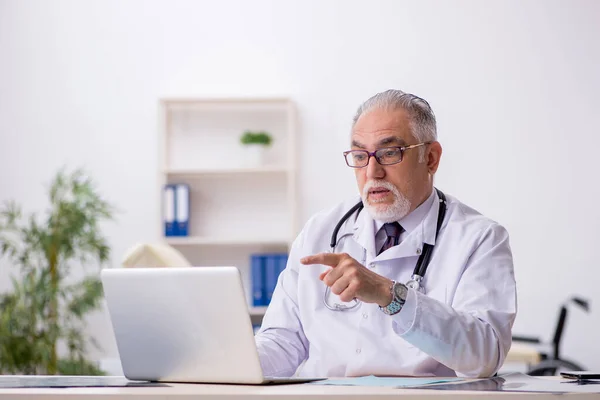 Hastanede çalışan yaşlı erkek doktor. — Stok fotoğraf