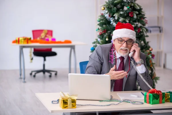 Funcionário idoso do sexo masculino comemorando o Natal no local de trabalho — Fotografia de Stock