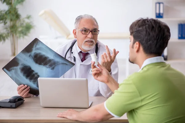 Paciente masculino joven que visita al radiólogo médico anciano —  Fotos de Stock