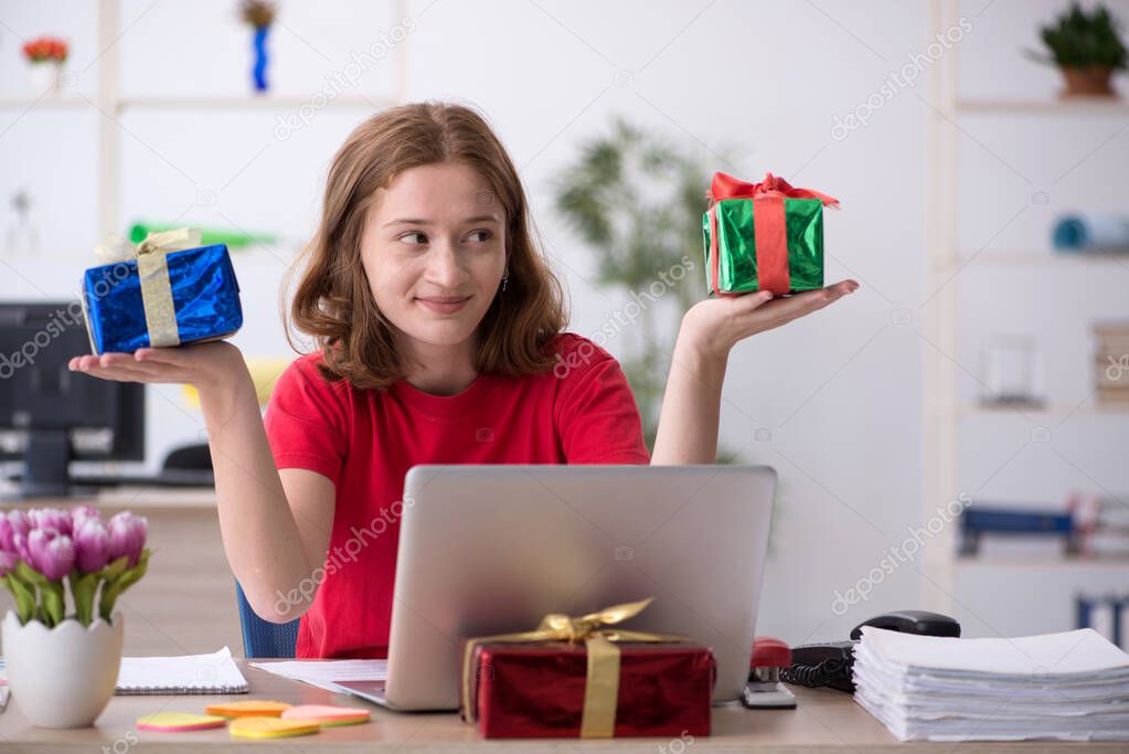 Young female designer celebrating Christmas in the office