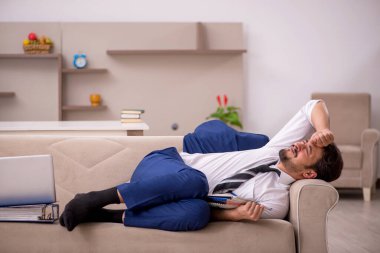 Genç erkek çalışan salgın sırasında evden çalışıyor.