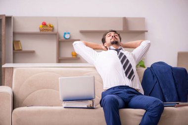 Genç erkek çalışan salgın sırasında evden çalışıyor.