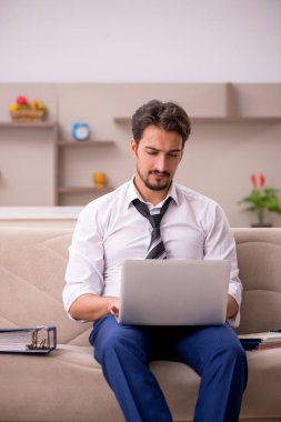 Genç erkek çalışan salgın sırasında evden çalışıyor.