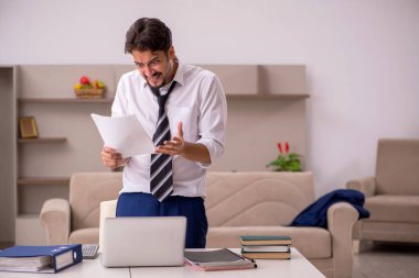 Genç erkek çalışan salgın sırasında evden çalışıyor.