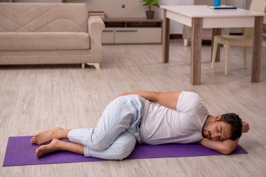 Genç adam evde spor yapıyor.