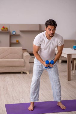 Genç adam evde spor yapıyor.