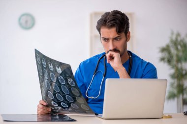 Klinikte çalışan genç bir erkek radyolog.