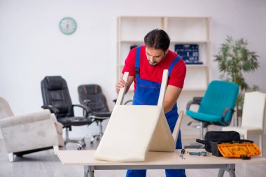 Genç erkek marangoz atölyede çalışıyor.