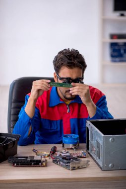 Bilgisayar tamir eden genç bir erkek tamirci.