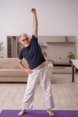 Yaşlı adam evde spor yapıyor.