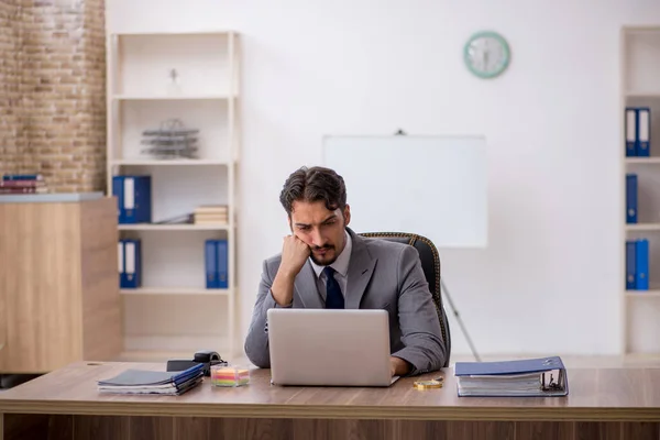 Jovem funcionário do sexo masculino sentado no escritório — Fotografia de Stock