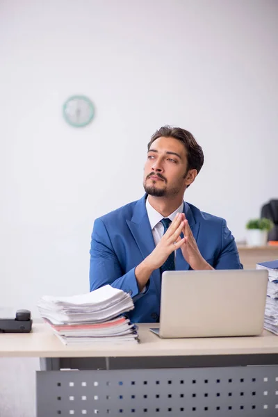 Jonge mannelijke werknemer en te veel werk op kantoor — Stockfoto