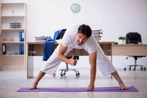 Junge männliche Angestellte beim Sport im Büro — Stockfoto