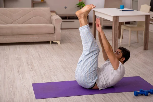 Jovem fazendo exercícios esportivos em casa — Fotografia de Stock