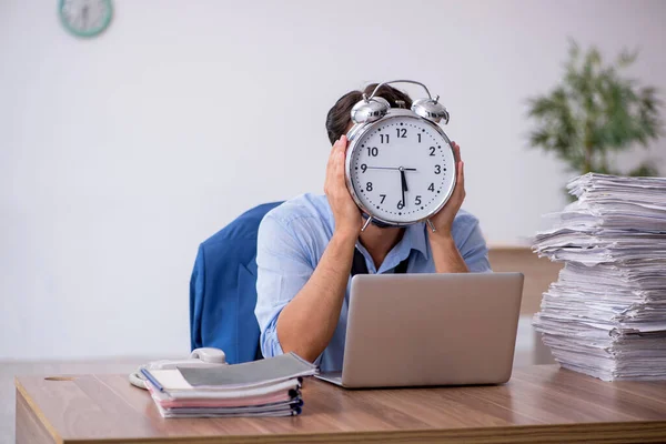 Joven empleado masculino en concepto de gestión del tiempo —  Fotos de Stock