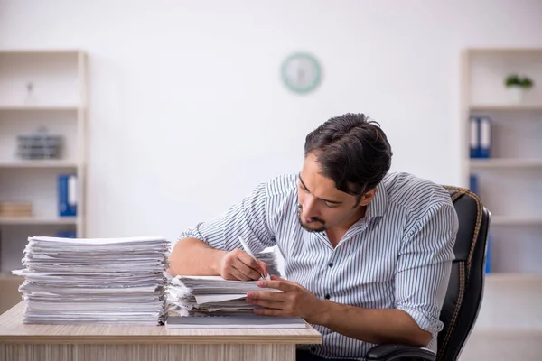 Ofisteki aşırı işten memnun olmayan genç bir erkek işçi.