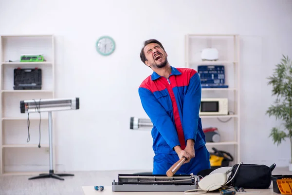 Mladý opravář mužského pohlaví opravuje klimatizaci — Stock fotografie