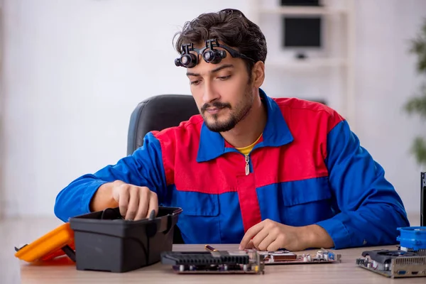 Bilgisayar tamir eden genç bir erkek tamirci.