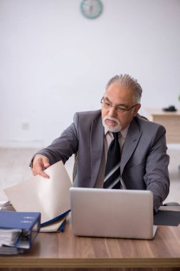 Ofiste çalışan yaşlı bir erkek.