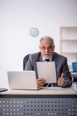 Ofiste çalışan yaşlı bir erkek.