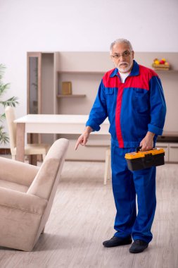 Yaşlı erkek marangoz içeride çalışıyor.