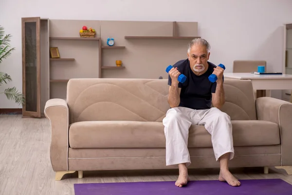 Yaşlı adam evde spor yapıyor. — Stok fotoğraf