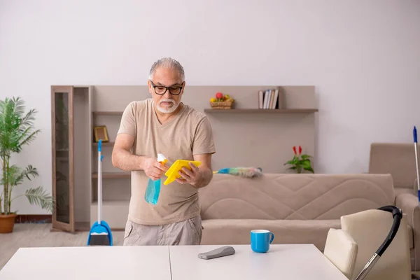 Az öregember házimunkát végez otthon. — Stock Fotó