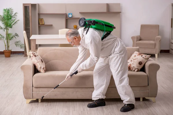 Viejo contratista masculino haciendo control de plagas en casa — Foto de Stock