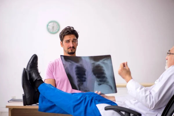 Fiatal férfi beteg látogató idős férfi orvos radiológus — Stock Fotó