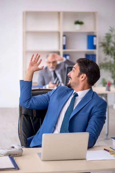 Gammal manlig chef och ung manlig anställd som arbetar på kontoret — Stockfoto