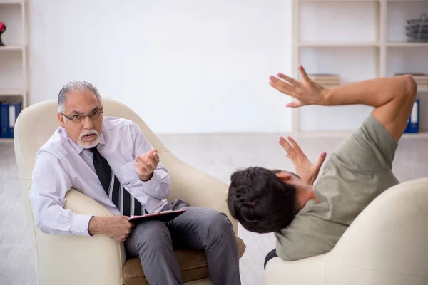 Jongeman op bezoek bij oude psycholoog — Stockfoto