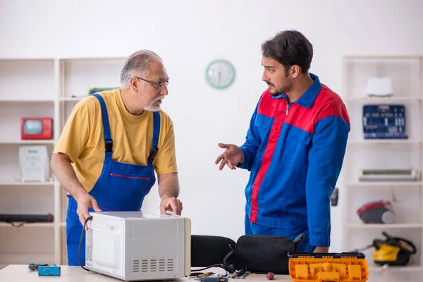 Två manliga reparatörer som arbetar på verkstad — Stockfoto